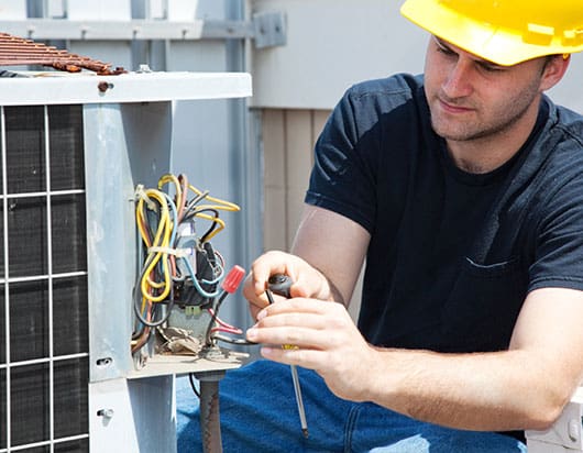 A technician repairing an ac unit.